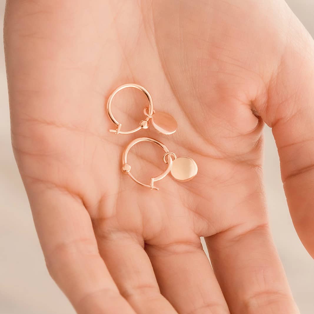 rose gold mini disc hoop earrings in hand